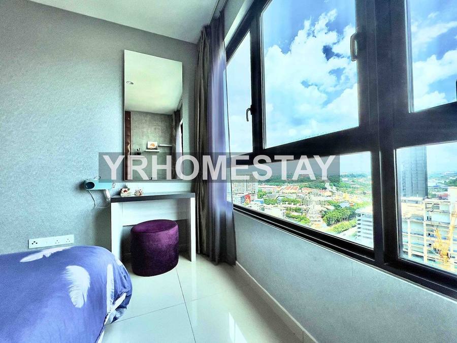 A desk and stool set against the full-height window, looking out over Shah Alam.